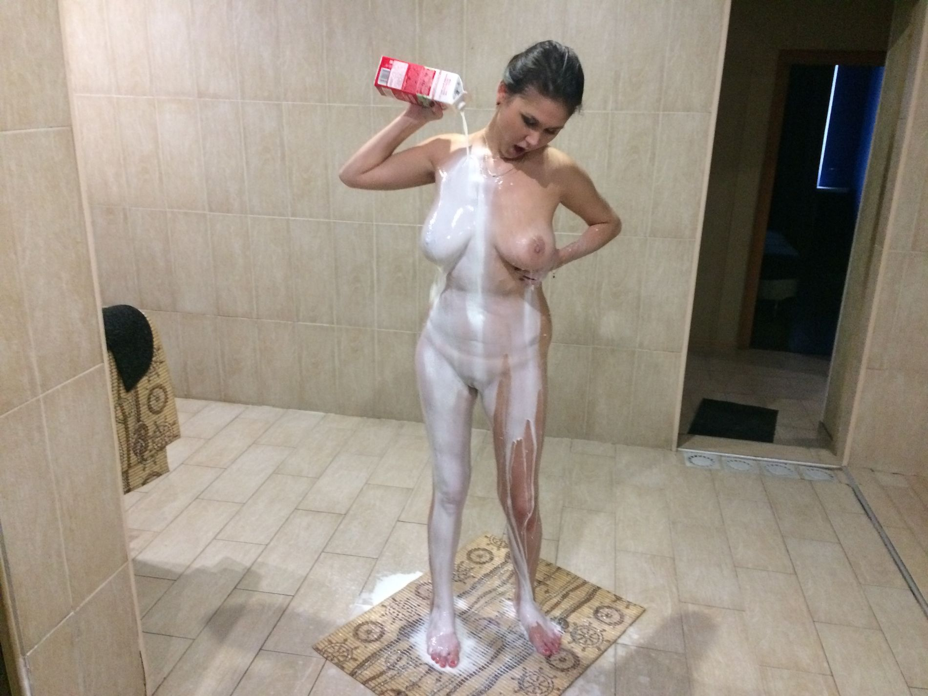 Naked girl with amazing tits showers in milk